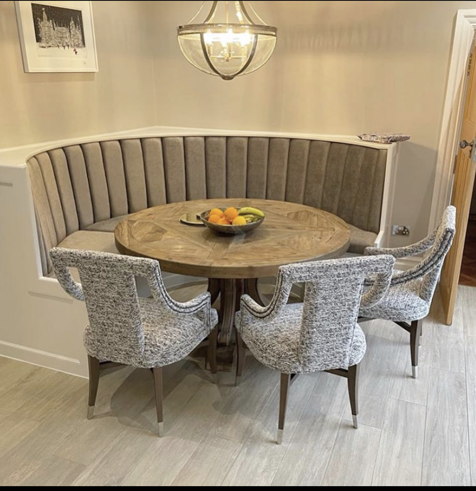 A large fluted, channel-stitched upholstered headboard fitted as a feature wall in a bedroom — workshop-built and installed